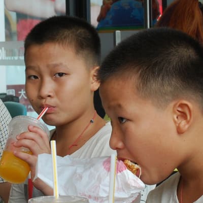 Ah-hei (till vänster) och hans bror äter hamburgare på en snabbmatsrestaurang.