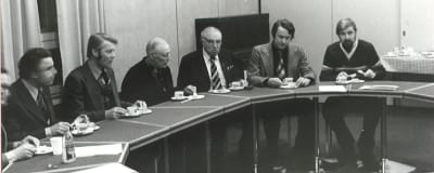 Sex personer sitter vid ett mötesbord