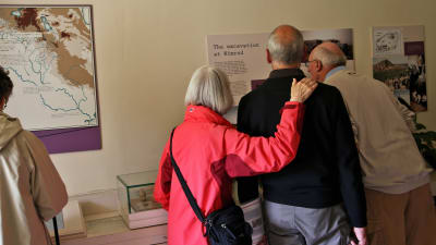 Besökare studerar arkeologiska utställningen i Greenway.