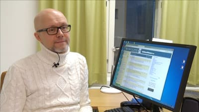 Jan Wickman sitter vid sin dator i arbetsrummet på Åbo Akademi.