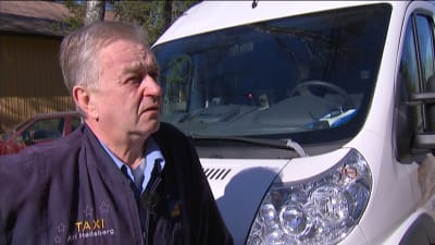 Taxichaufför utanför sin bil.