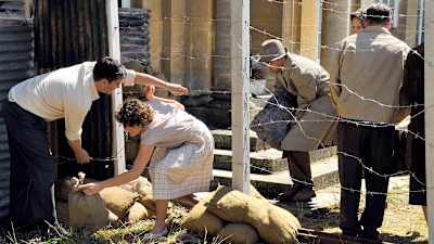 Ihmiset pyrkivät piikkilanka-aidan läpi.