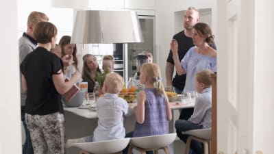 Familjer med barn runt ett matbord.