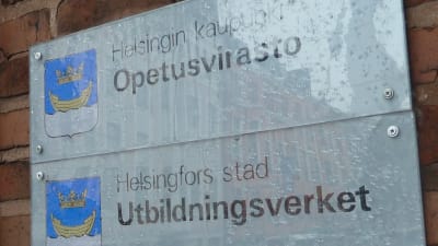 En regnvåt skylt där det står Helsingfors stad Utbildningsverket.