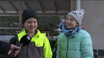 Pojke och flicka intervjuas på skolgård