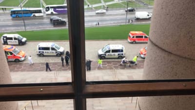 Knivhuggning utanför riksdagshuset, polisbilarna fotograferade genom ett fönster. 