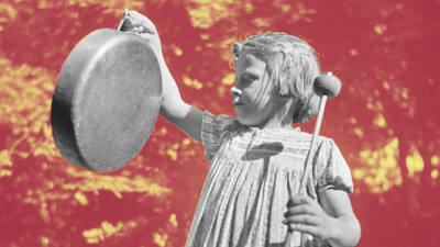 En flicka som slår på en gonggong.