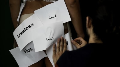 Modeskaparen Bahaulddin Rawi justerar papperslappar på modellen Ia Wilsons kropp. 