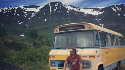 Bosse Hellsten vid en buss i bakgrunden berg