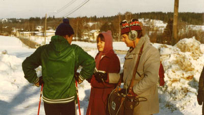 Två radiojournalister intervjuar en skidåkare.