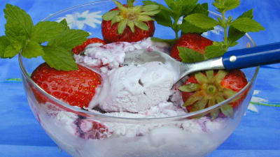 Vaniljglass och jordgubbar i en glasskål