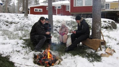Daniel Eriksson med sina barn och sin svägerska, grillar korv på baksidan av huset