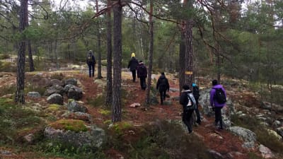 Kvinnor vandrar upp för en bergskulle.