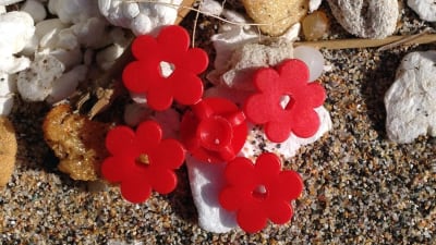 Röda legoblommor på en sandstrand.