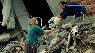 En kvinna får hjälp med att hitta sina kläder i bråte efter jordbävning i Izmit
