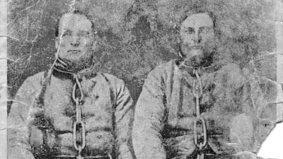 Puukkojunkkarit Antti Rannanjärvi ja Antti Isotalo istuvat vierekkäin raskaissa kahleissa noin 1920-luvulla painetussa postikortissa. Kuvan alle on painettu osa heistä kertovan kansanlaulun säkeistöstä. Alkuperäisen kuvan on ottanut Julia Vidgrén 1869.