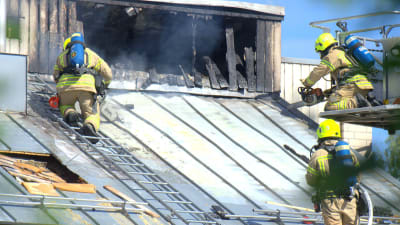 Räddningstjänsten tvingas såga upp taket för att komma åt brandhärden.