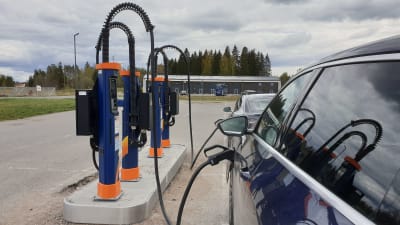 Två elbilar laddas vid en snabbladdare i Riihimäki.