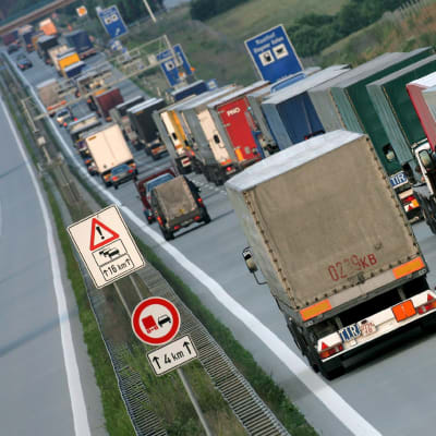 Lastbiler i kö på Autobahn i Tyskland