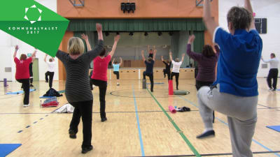 Pensionärer motionerar i en gymnastiksal.