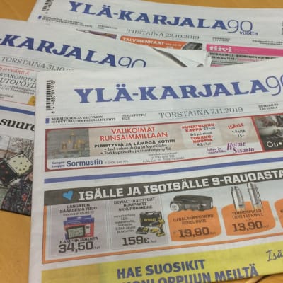 Ylä-Karjala paikallislehtiä pöydällä. 