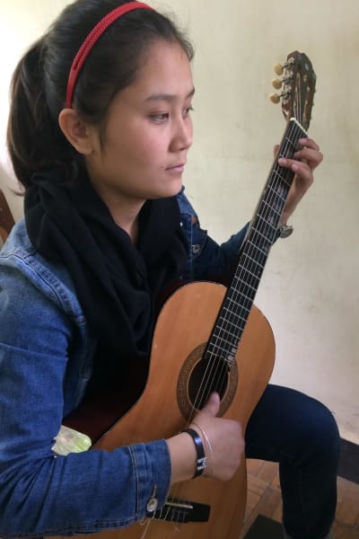 Shukria Fawzi spelar gitarr. Slöjan behövs inte på Afghanistans nationella musikinstitut.