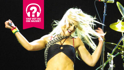 Gwen Stefani på scenen, leende och med fladdrande hår.