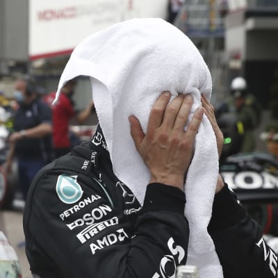 Valtteri Bottas begraver ansiktet i en handduk.