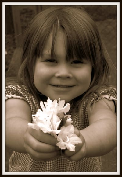 Flicka med blommor i handen.