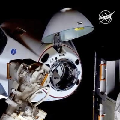 Rymdkapseln Chew Dragon dockar vid rymdstationen ISS.