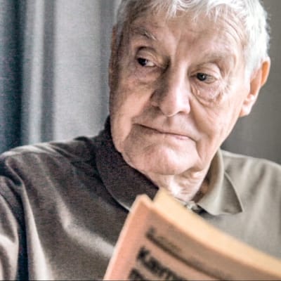 Otto läser tidningen och kastar en blick åt sidan.