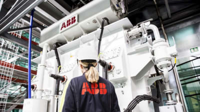 ABB-anställd i fabriken står framför en maskin.