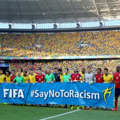 Spelare med en banderoll "#SayNoToRacism"