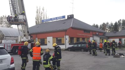 Brandmän står samlade kring ett hus som har skylten Hotel Polaris på taket. Ingen brand, inga lågor, ingen rök syns på bilden.