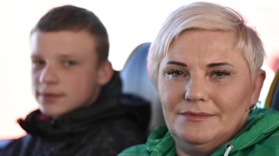 En kvinna med sin tonårsson. De ser in i kameran.