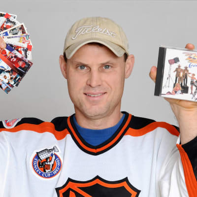 Zarley Zalapski visar upp hockeykort och en skiva.