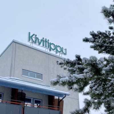 Lappajärven kylpylä-hotelli Kivitippu, katolla vihreä logo. Oikealla iso kuusi.