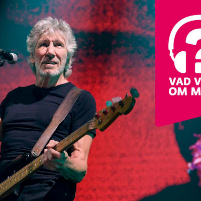 Roger Waters har en elbas kring halsen, står bakom en mikrofonställning och håller upp höger hand en aning.