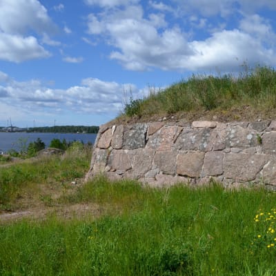 Fort Katariinan linnoituksen muuria, taustalla HaminaKotkan sataman Mussalon rakenteita.