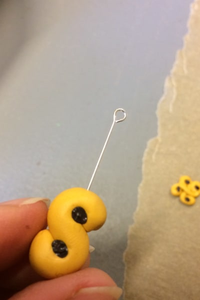 Smycken gjorda av miniatyrlussebullar i hobbylera där en metallögla trycks in i en liten s-formad bulle