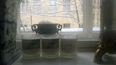 tre doftljus i rad på ett fönsterbräde