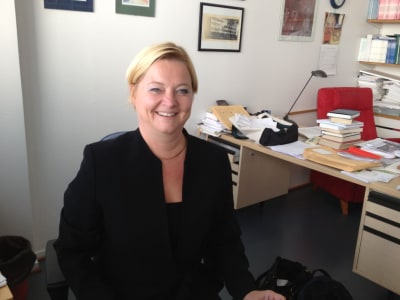 Leende kvinna vid skrivbord, föreställer professor Malin Brännback vid Åbo Akademi.