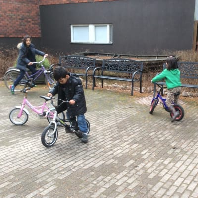 Barn till asylsökande cyklar utanför hotell Mäntyniemi i Pyttis