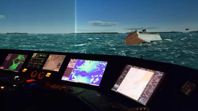 En simulator, i bakgrunden syns ett fartyg som fått slagsida. Längst fram skärmar.