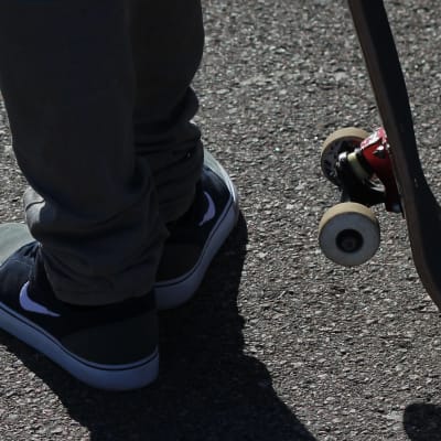 En skateboardåkares bräda och fötter.