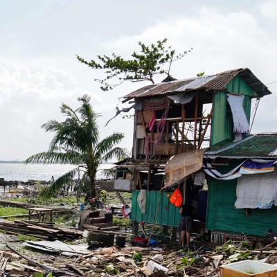 Bräder och skräp ligger på en strand efter tyfon i filippinerna.