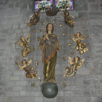 Maria-patsas ympärillään pikkuenkeleita Barcelonan Santa Maria del Mar -katedraalin seinällä.