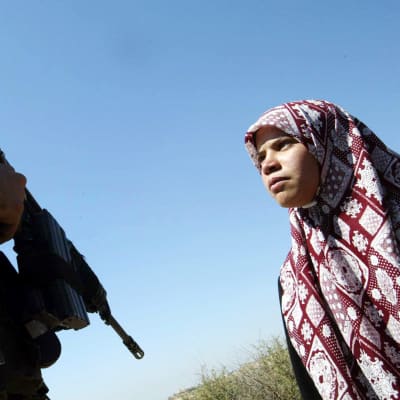 Palestinsk flicka och israelisk soldat i byn Al Zawiya på Västbanken.
