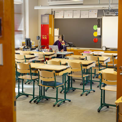 Luokanopettaja Taru Kantonen pitämässä etäopetusta tyhjässä luokkahuoneessa. 