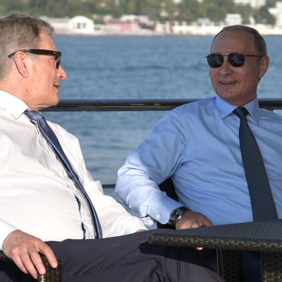 Sauli Niinistö och Vladimir Putin talar på en båt.